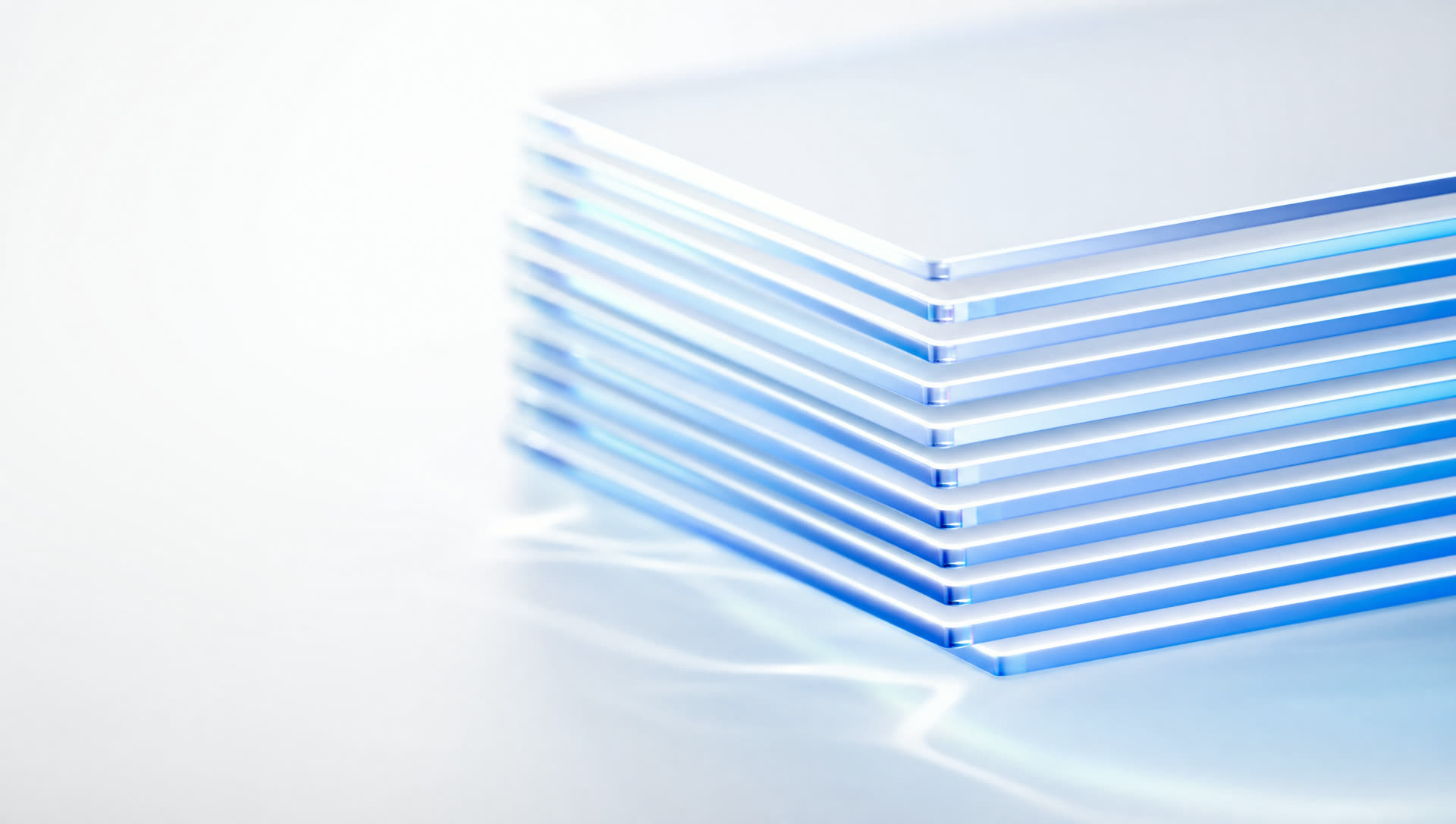 A neat stack of glass sheets, edges glowing blue